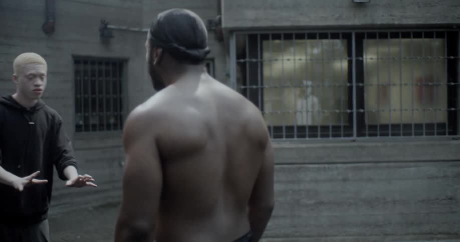 A man pushes someone in front of the building
