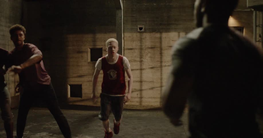 A group of young men play basketball together
