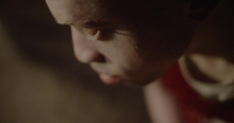 A male teenager with a sad look on his face looks around