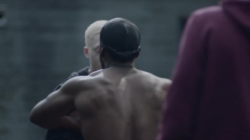A teenager is scared as a man shoves him