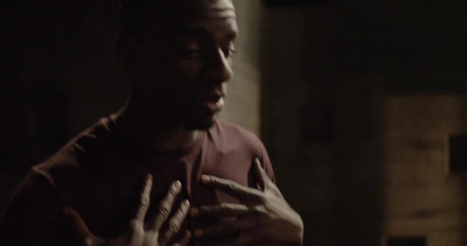 A man gestures by putting his hands to his chest then holding out while he talks