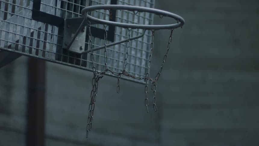 Basketball being tossed in a hoop with broken chains