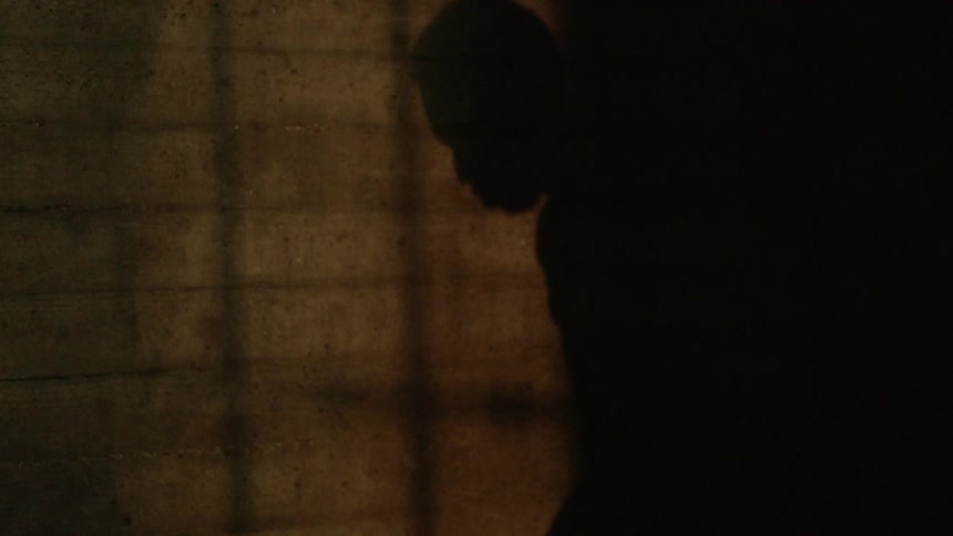 A man dribbles a basketball in the dark