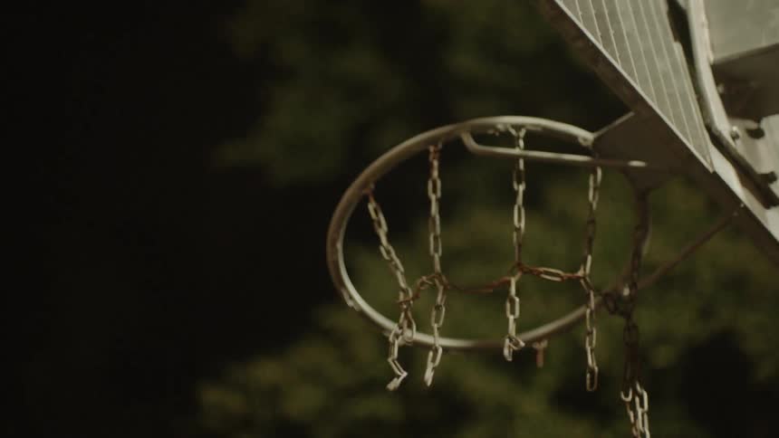 A basketball is thrown at a basketball hoop and bounces off the rim