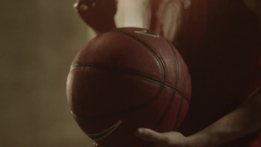A man moves a basketball in his hands