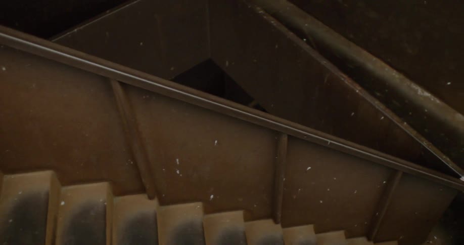 A man covered in white body paint sprints down steps
