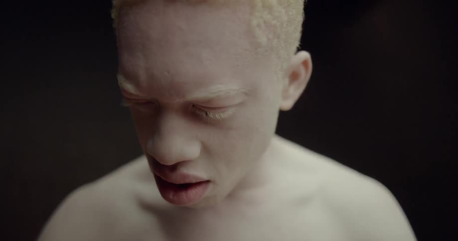 A young white teenager shakes his head and looks around