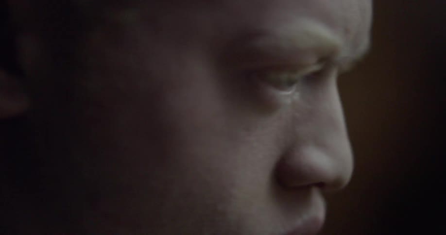 Man blinks as he turns his head to the right