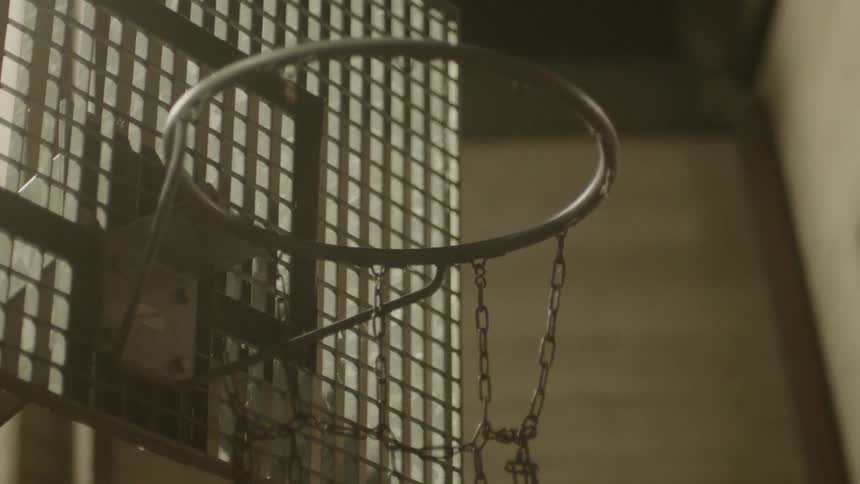 A basketball hits the hoop