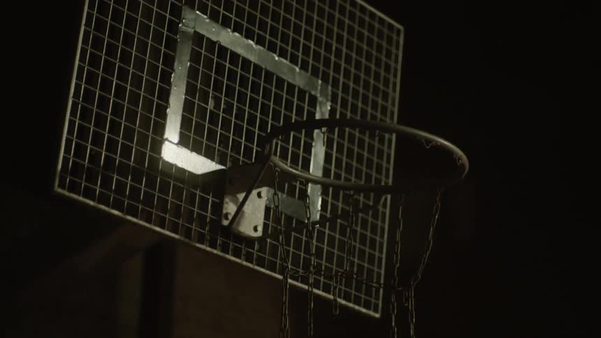 Light reflects off a dilapidated basketball hoop