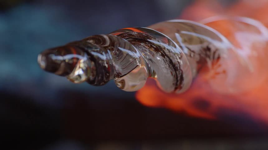 A fire burns around a piece of rotating glass