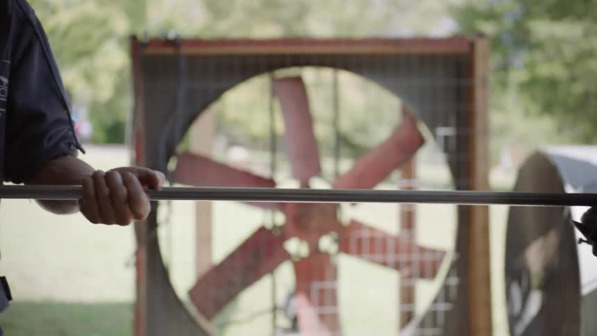 A man holding a pole with the other end in a furnace