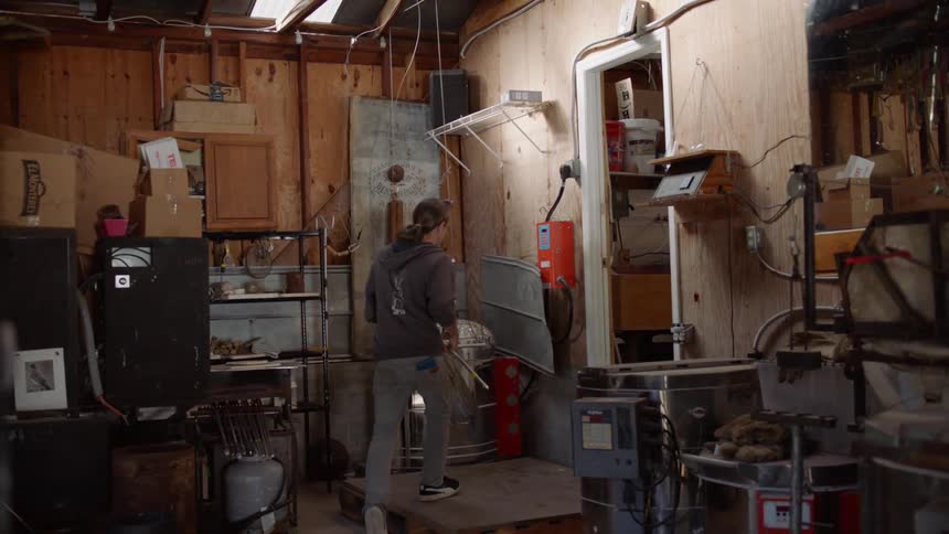 Man crosses workshop to open hot kiln