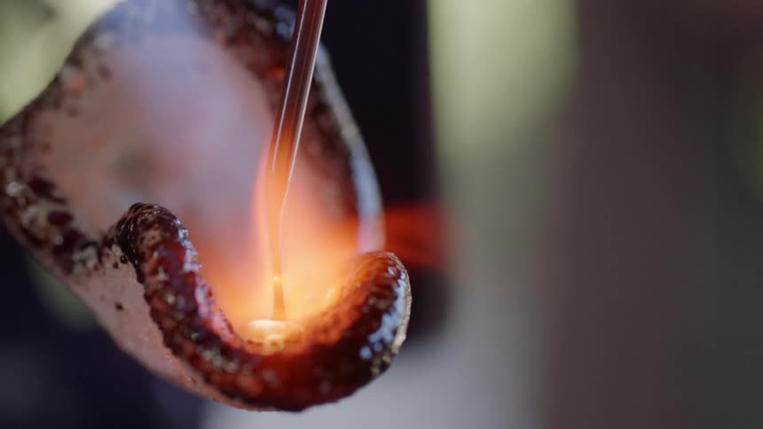 A person forming glass with a torch and tool