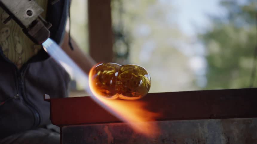 A man is blowing glass with a torch