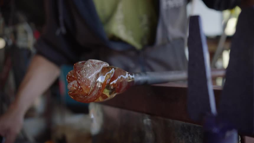 A person spins a pole with decorative glass on the end