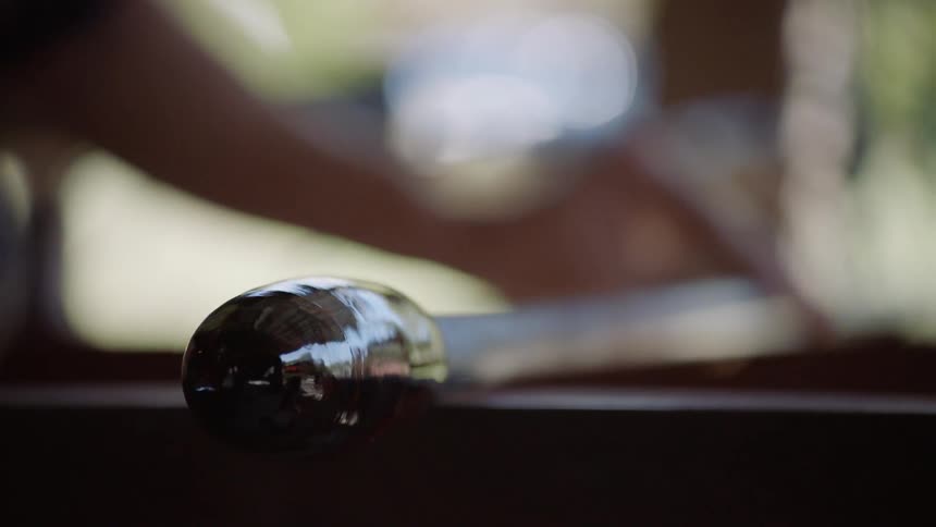 A person is rolling glass on a rod