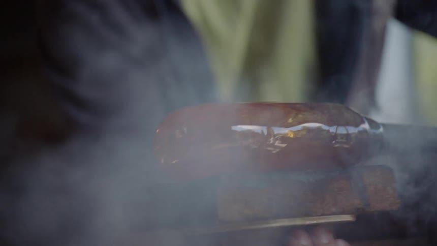 A blacksmith using a tool to mold the end of a rod