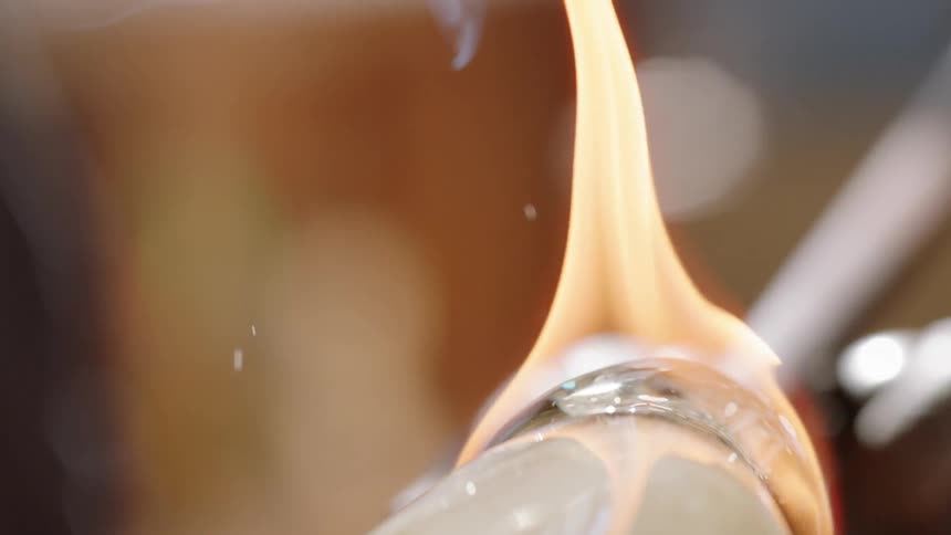 Glass is shaped and turned over an open flame