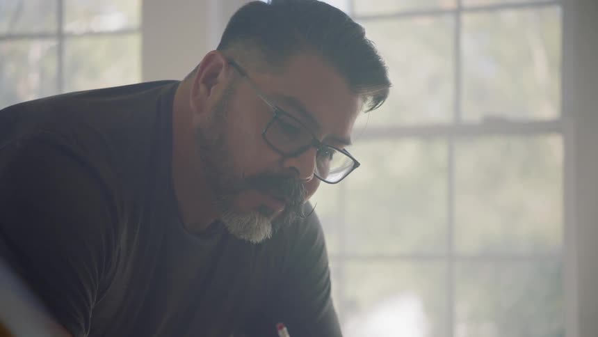 A man looks at a plan and writes on it