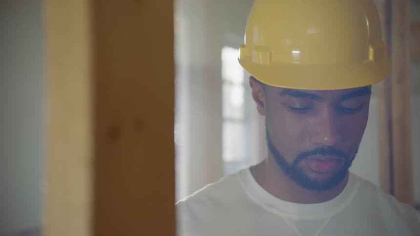 A man in a hard hat looks at a beam