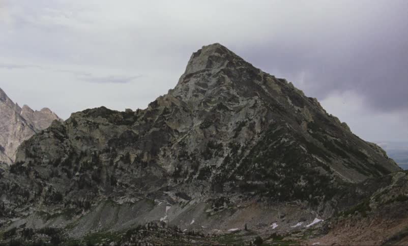 Clouds hang over a mountain peak