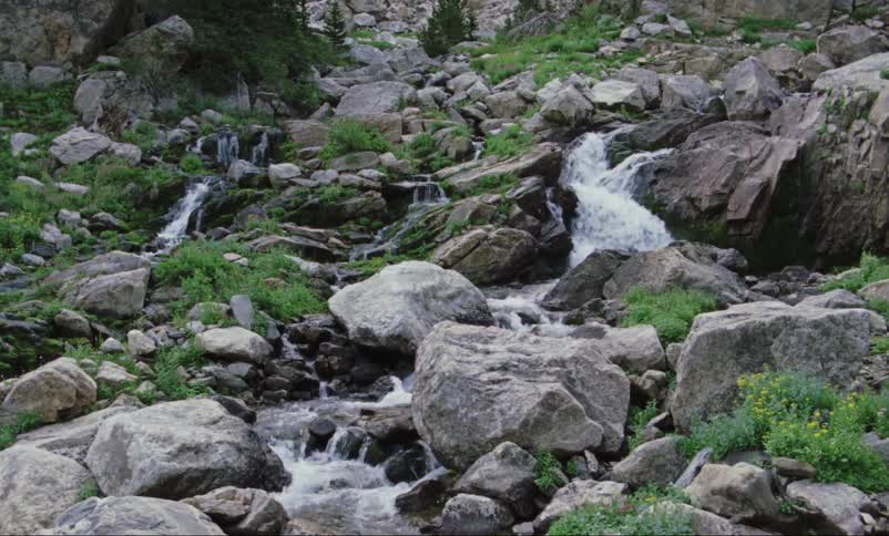 The stream runs downhill on the rocks