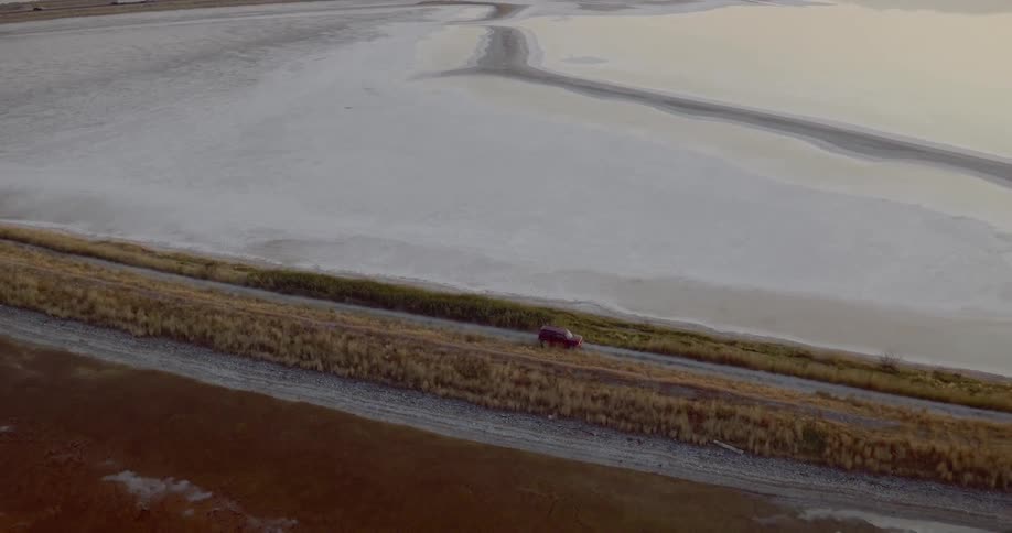 A car travels down a rural two lane road