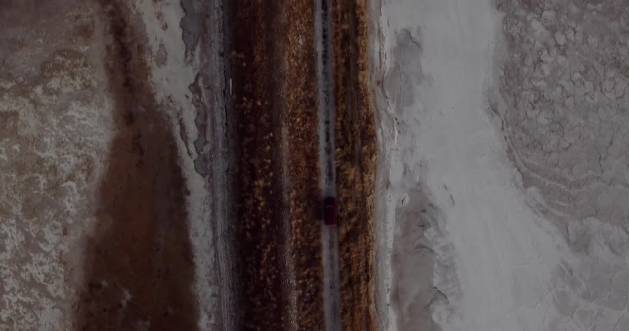 The cars drive past the beach below