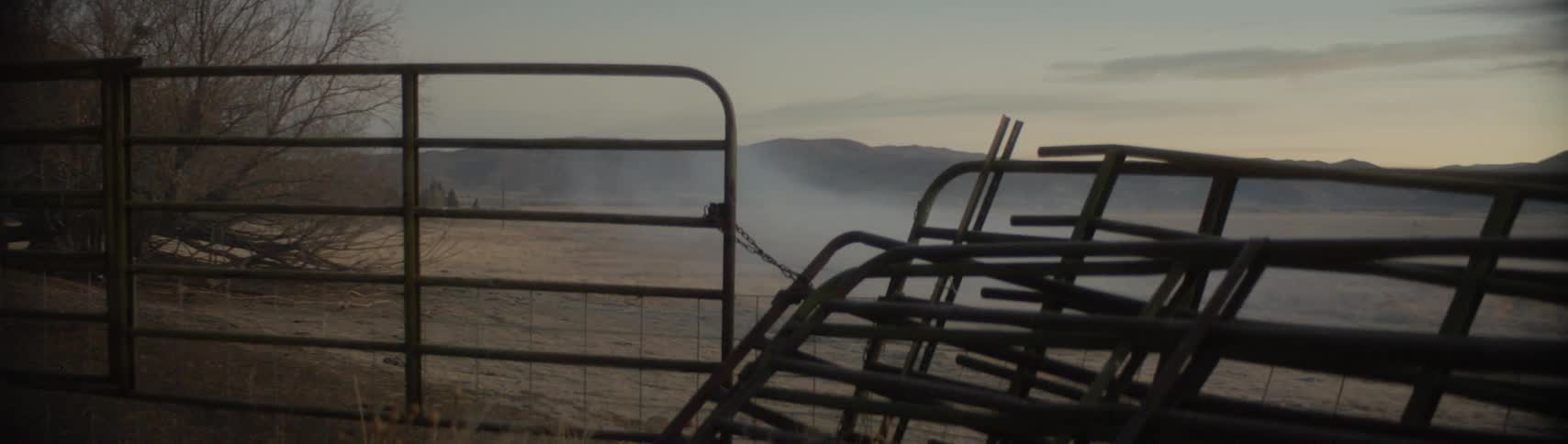 View of foggy and hills behind a broken fence