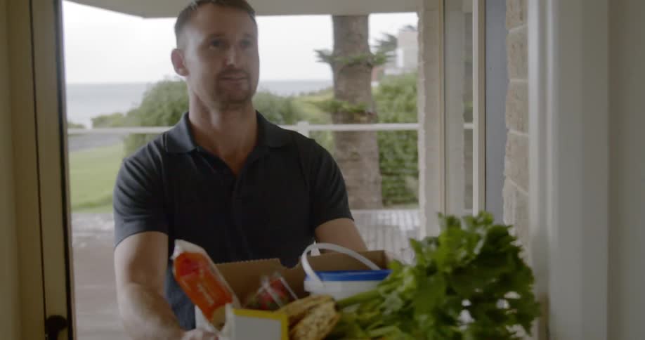 Man waiting on porch delivery box of groceries