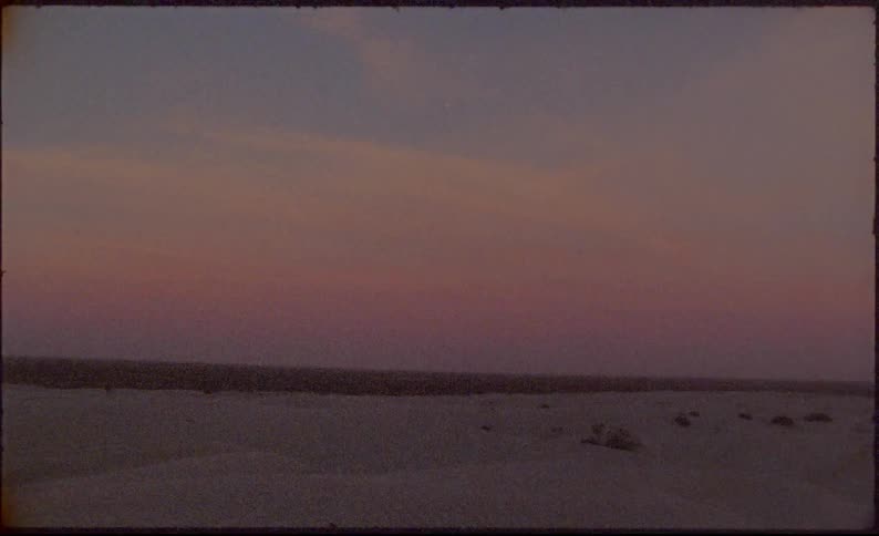 A red sky hangs above a desert landscape