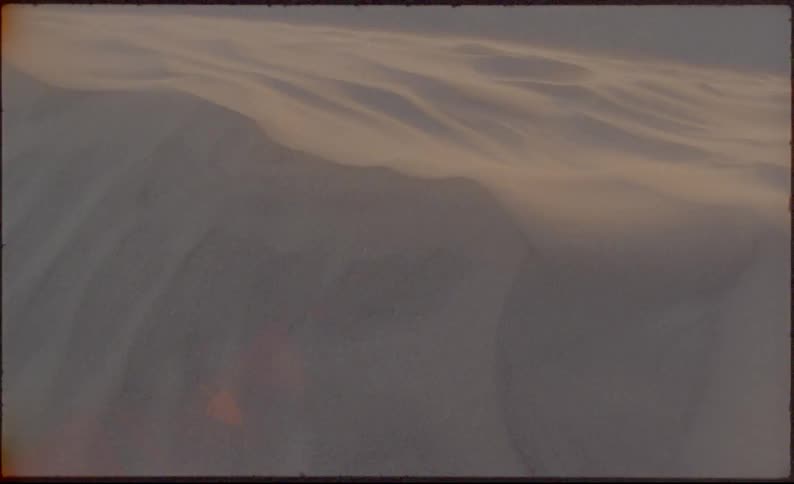 Snow blowing in ridges across arctic landscape