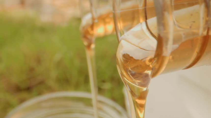 Honey is being poured from jars on a farm