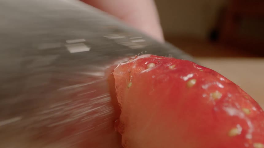 Sharp knife slices through a red strawberry