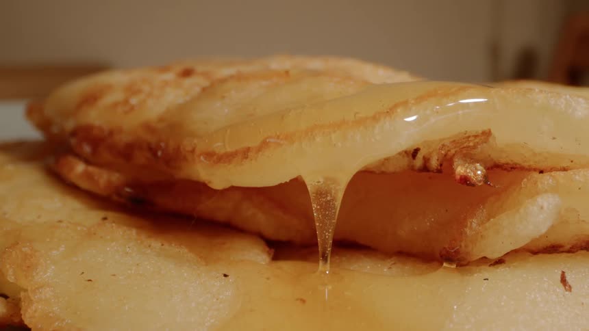 The syrup slowly drops from the pancakes