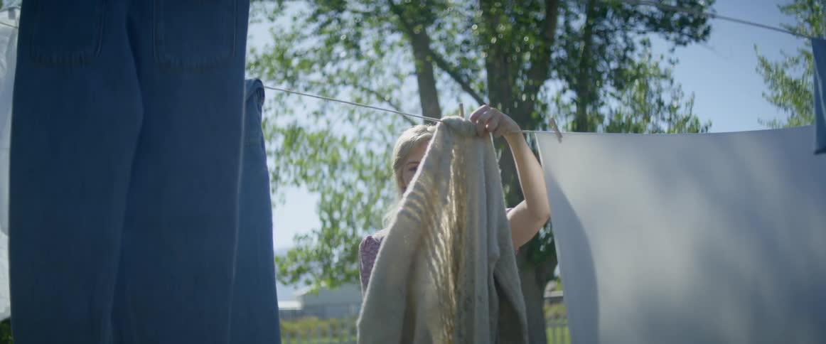 Mother and daughter hanging laundry on an outdoor clothesline