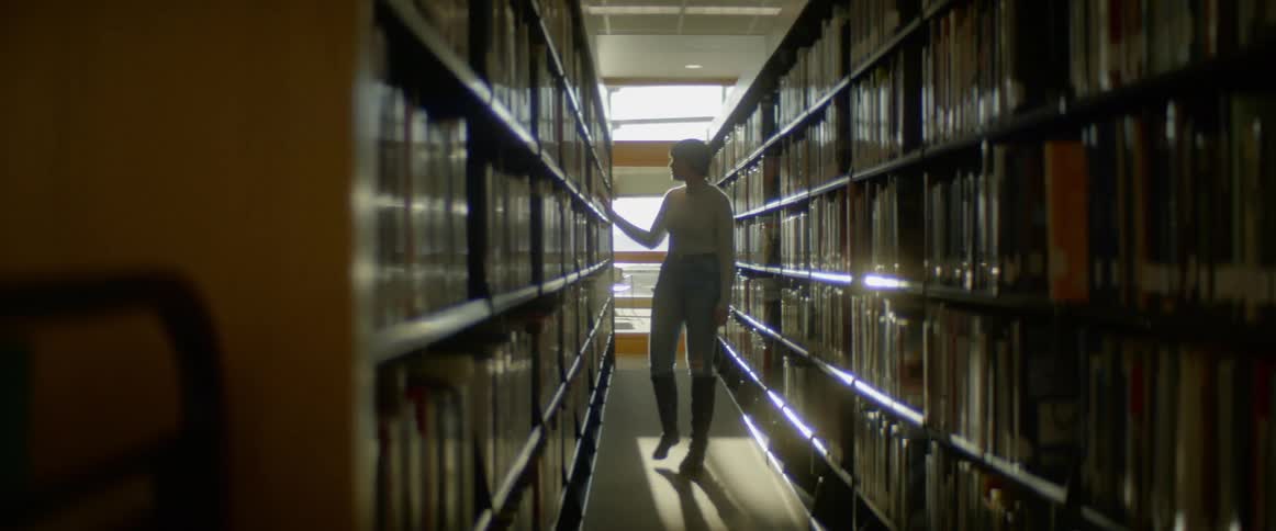 Woman browsers along library stacks