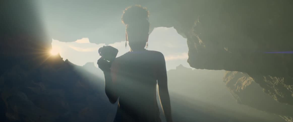 A woman carries a camera through the cave