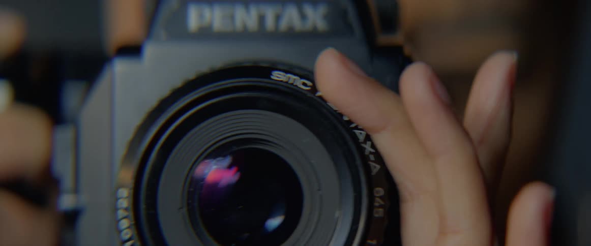 A photographer carefully adjust the lens of a camera