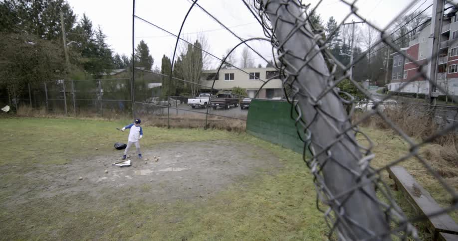 A boy stands at home plate with a bat on a baseball field