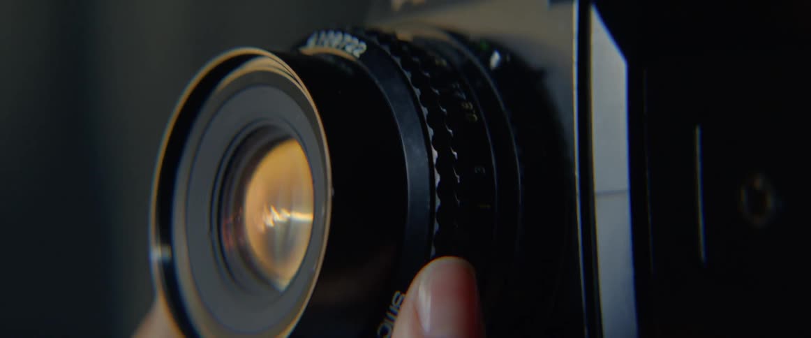 A person turns the lens on the camera