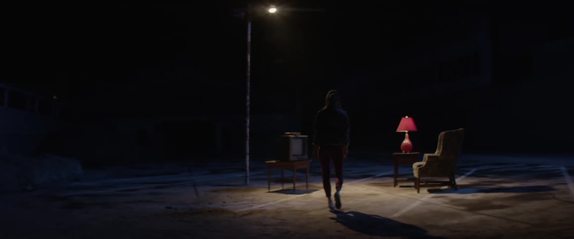 Woman walks toward living room furniture place outdoors under light