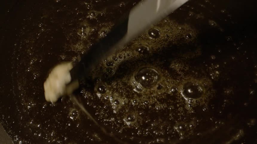 Hot pan greased with butter using a knife