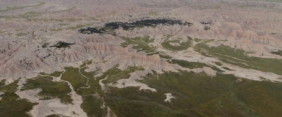 Eroded mountains rise out of a green landscape