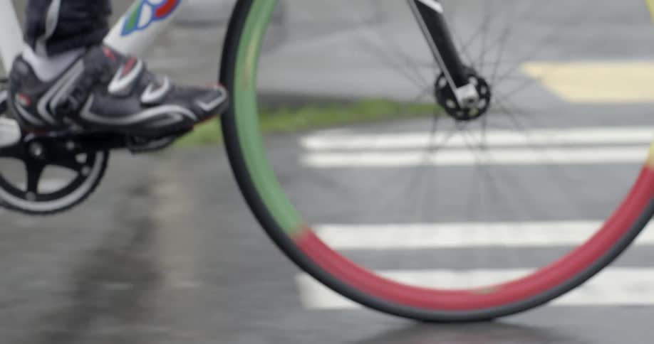 Person riding a bike down a wet city street
