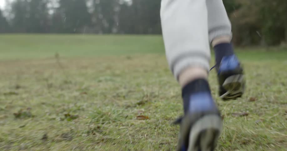 A baseball player runs to first base in the rain