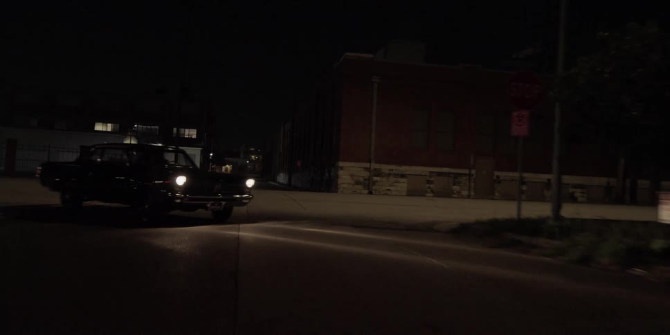 A low riding vehicle turns onto a street at night