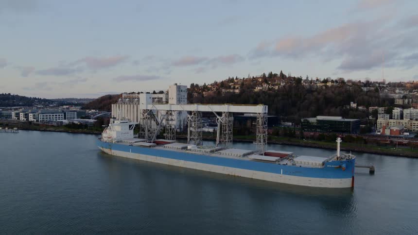 Ascending orbit around a cargo vessel docked at a grain shipping terminal