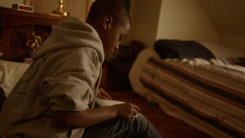 A man is folding a paper on his lap